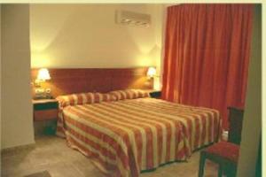 Habitación de hotel con cama y cortina roja en Gran Hostal El Chiscón, en Colmenar Viejo