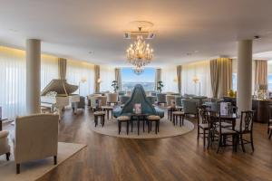 a waiting room with tables and chairs and a piano at Luna Hotel Turismo in Abrantes