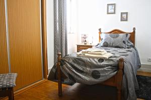 a bedroom with a bed with a blanket on it at Casa Azul Altamira in Viana do Castelo