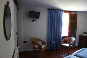 Una televisión o centro de entretenimiento en Hotel Mesón del Gallo