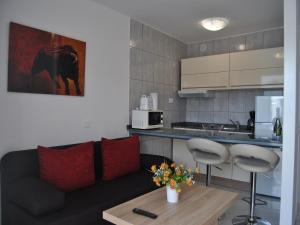 Una sala de estar con un sofá y una cocina. en Aparthotel MONTERREY, en Puerto Rico de Gran Canaria