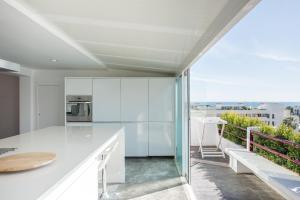 a kitchen with white cabinets and a balcony at Marina Vilamoura Triplex in Vilamoura