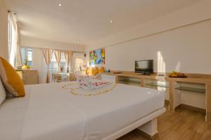 a bedroom with a large white bed and a living room at Casa Luca in Playa del Carmen