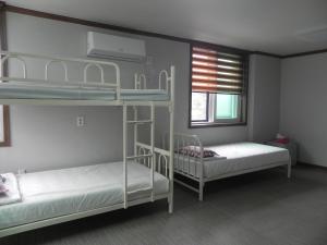 全州市Jeonju International Hostel的一间卧室，有两张双层床和一扇窗户
