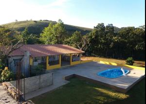 a house with a swimming pool in the yard at Pousada Dedo de Deus in Paraisópolis