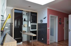 uma cozinha com armários pretos e uma parede vermelha em Villa Prinz Heinrich _ Panoramabli em Sassnitz