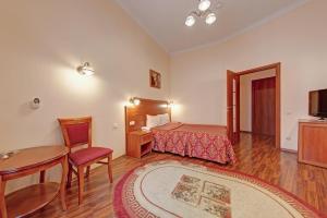 a hotel room with a bed and a table and chair at Atria Guest House in Saint Petersburg