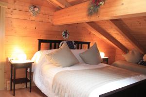a bedroom with a bed in a log cabin at Baita Zeni Tirolerhof in Fiera di Primiero
