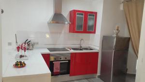 ネルハにあるMagnifico piso en Nerjaのキッチン(赤いキャビネット、ステンレス製の冷蔵庫付)