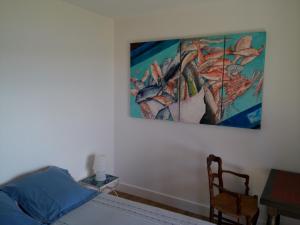 a bedroom with a bed and a painting on the wall at Villa Mirabel in Île du Levant