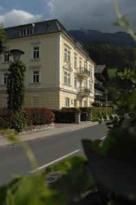 un gran edificio blanco al lado de una calle en Romantik Residenz (Ferienwohnungen Hotel Im Weissen Rössl) - Dependance, en St. Wolfgang