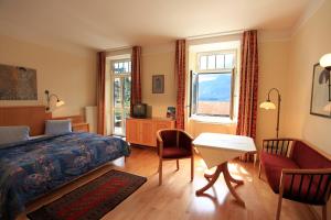 Habitación de hotel con cama, mesa y sillas en Romantik Residenz (Ferienwohnungen Hotel Im Weissen Rössl) - Dependance, en St. Wolfgang