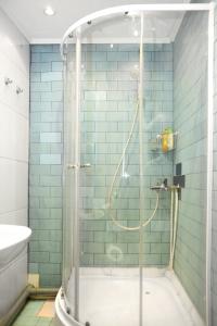 y baño con ducha de azulejos azules. en Apartment on Elninskay 18 en Moscú