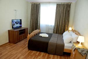 a bedroom with a bed with a television and a window at Apartment at Osenniy Bulevard 7 in Moscow