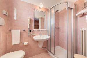 różowa łazienka z umywalką i prysznicem w obiekcie Hotel Oasi w mieście Cortina dʼAmpezzo