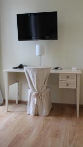 a white desk with a television on a wall at Castellu in Lucciana