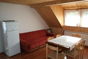 sala de estar con sofá rojo y mesa en Apartments Nino, en Jasenak