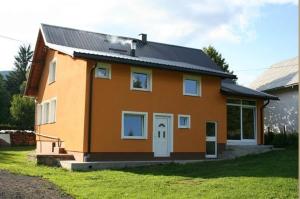 a small orange house with a black roof at Apartments Nino in Jasenak