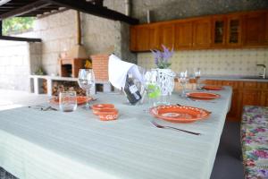 een witte tafel met borden en glazen erop bij AboimHouse in Amarante