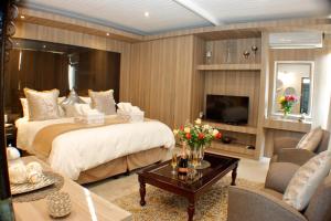 a bedroom with a large bed and a living room at Keret Accommodation in Bellville