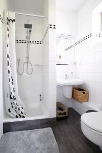 ein Bad mit einer Dusche, einem WC und einem Waschbecken in der Unterkunft the Mulang House in Kassel