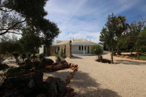 een wit huis met bomen en een grindoprit bij L&F House in Algoz