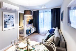 un soggiorno con divano e tavolo di Friendhouse Apartments Vistula&Wawel a Cracovia