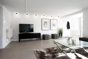 a white living room with a tv and a glass table at Wow Apartments Örgryte in Gothenburg
