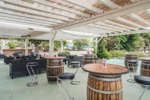 a patio with bar stools and a pergola at Azureva Cap d'Agde in Cap d'Agde