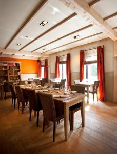 a large dining room with a long table and chairs at Hotel Thermen Dilbeek in Dilbeek