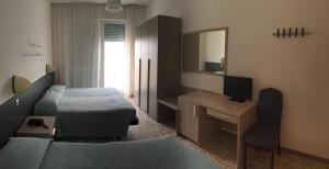 a room with a couch and a bed and a television at Hotel Mareblu in Senigallia