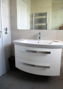 W łazience znajduje się biała umywalka i lustro. w obiekcie Appartement Cattleya - rue halevy w Nicei