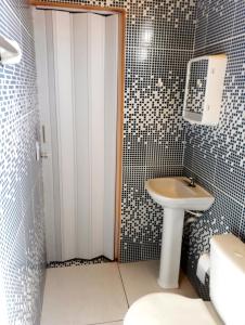 卡諾格布拉達的住宿－Suítes Canaã，浴室配有白色水槽和卫生间。
