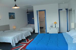 two beds in a room with blue walls at Le France in Loudéac +43 photos