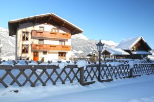 a house with a fence in the snow at Rosspointnerhof in Haus im Ennstal