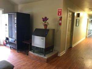 een woonkamer met een flatscreen-tv op een open haard bij Outpost Motel in Dripping Springs