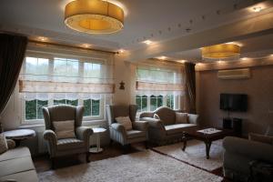 ein Wohnzimmer mit Sofas und Stühlen und Fenstern in der Unterkunft Damla Pansiyon in Sapanca