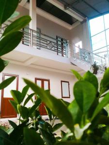 a building with a balcony and plants in front of it at Homestay Moc Chau in Mộc Châu