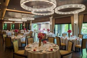 a banquet room with tables and chairs and chandeliers at Hotel Floracion Nasu in Nasu