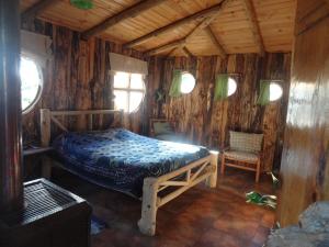 um quarto com uma cama num chalé de madeira em Cabanas Curi-Huapi em Isla Negra