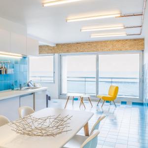 パラヴァ・レ・フロにあるSuperbe appartement sur la plage - Le Zénithのキッチン、海の景色を望むダイニングルーム