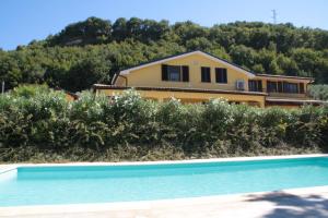 een huis op een heuvel met een zwembad bij La Dolce Vallata in Montefiore dellʼAso