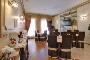 a dining room with tables and chairs and a television at Atria Guest House in Saint Petersburg