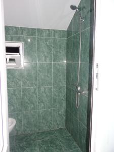 a bathroom with a shower with a green tile wall at Festina Lente in Kobuleti +74 photos
