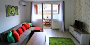 ブダペストにあるGrand Trees Apartmentのリビングルーム(グレーのソファ、赤い枕付)