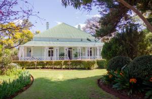 ein weißes Haus mit Garten und Rasen in der Unterkunft Adley House in Oudtshoorn