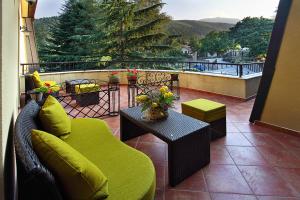 a balcony with a green couch and a table at Hotel Šator in Bitola