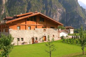 a house in a field with a mountain in the background at Locanda Borgo Chiese in Condino