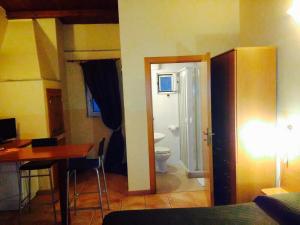 a room with a bathroom with a toilet and a desk at Corato room economy in Corato