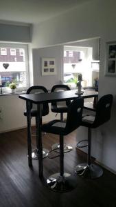 a table and chairs in a room with a kitchen at FeWo Wilhelmshaven Voslapp 267 in Wilhelmshaven